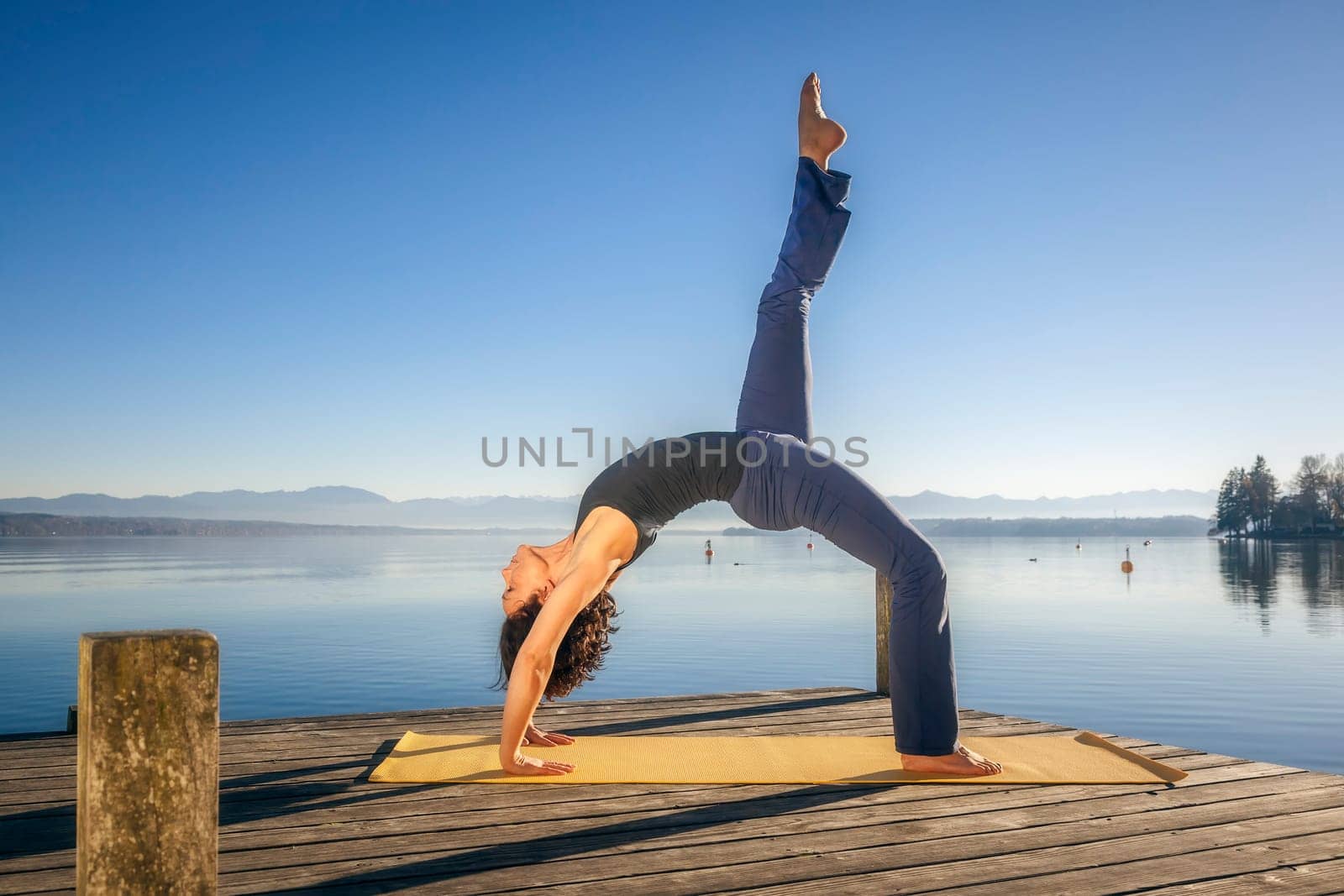 An image of a pretty woman doing yoga at the lake