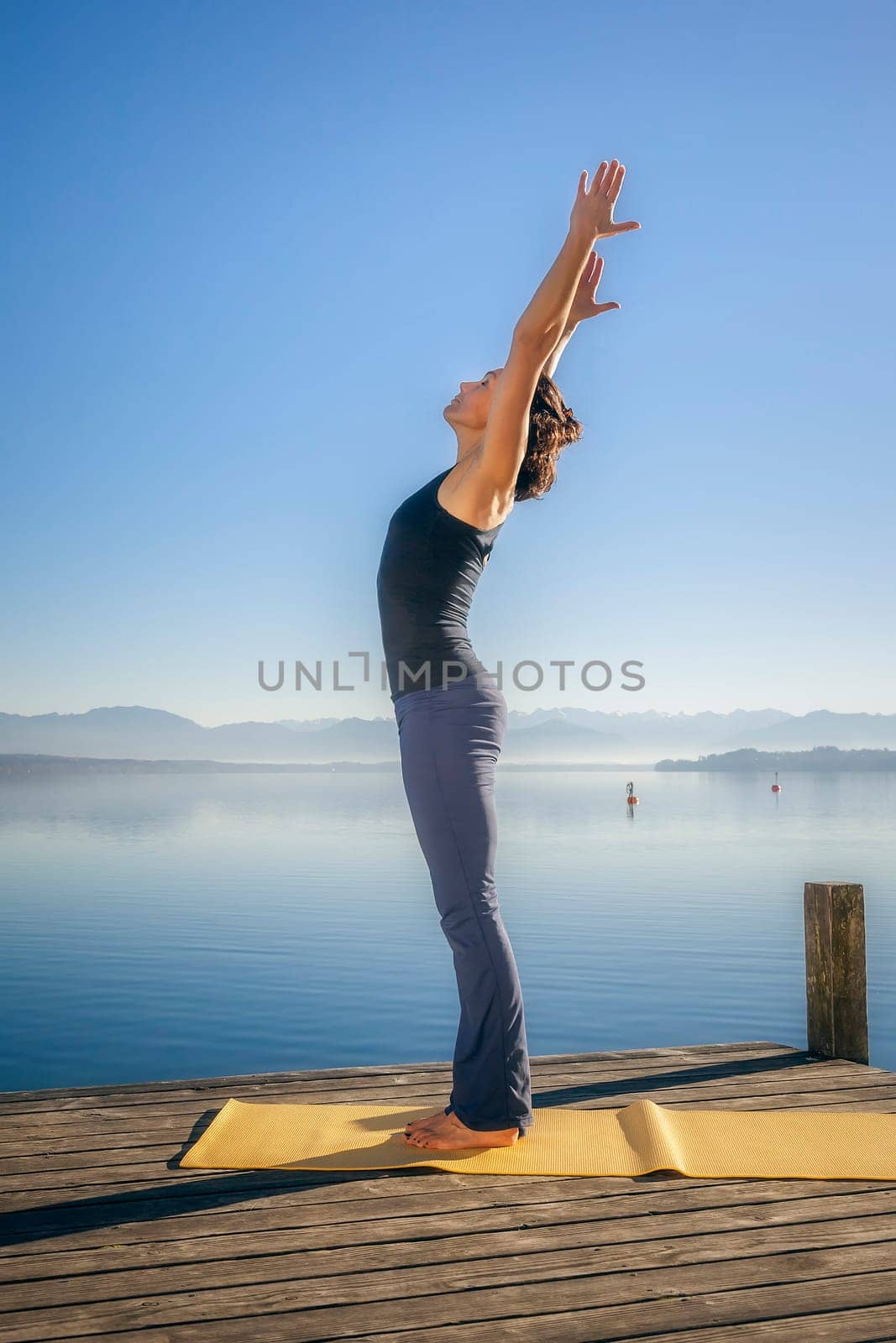 An image of a pretty woman doing yoga at the lake