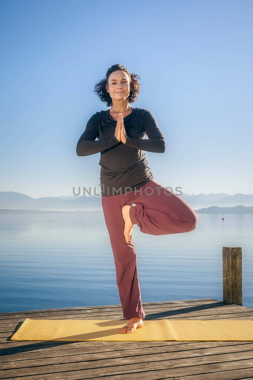 An image of a pretty woman doing yoga at the lake