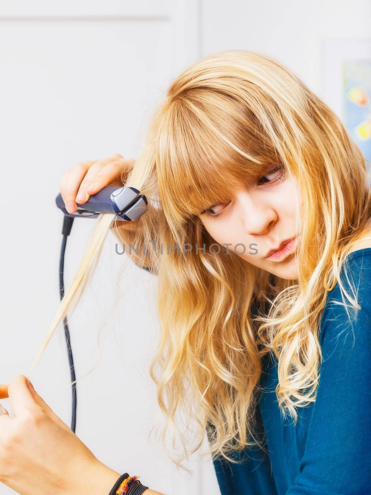 An image of a beautiful teenage girl smooting her hair