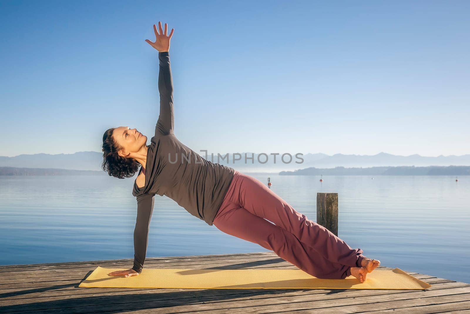 An image of a pretty woman doing yoga at the lake
