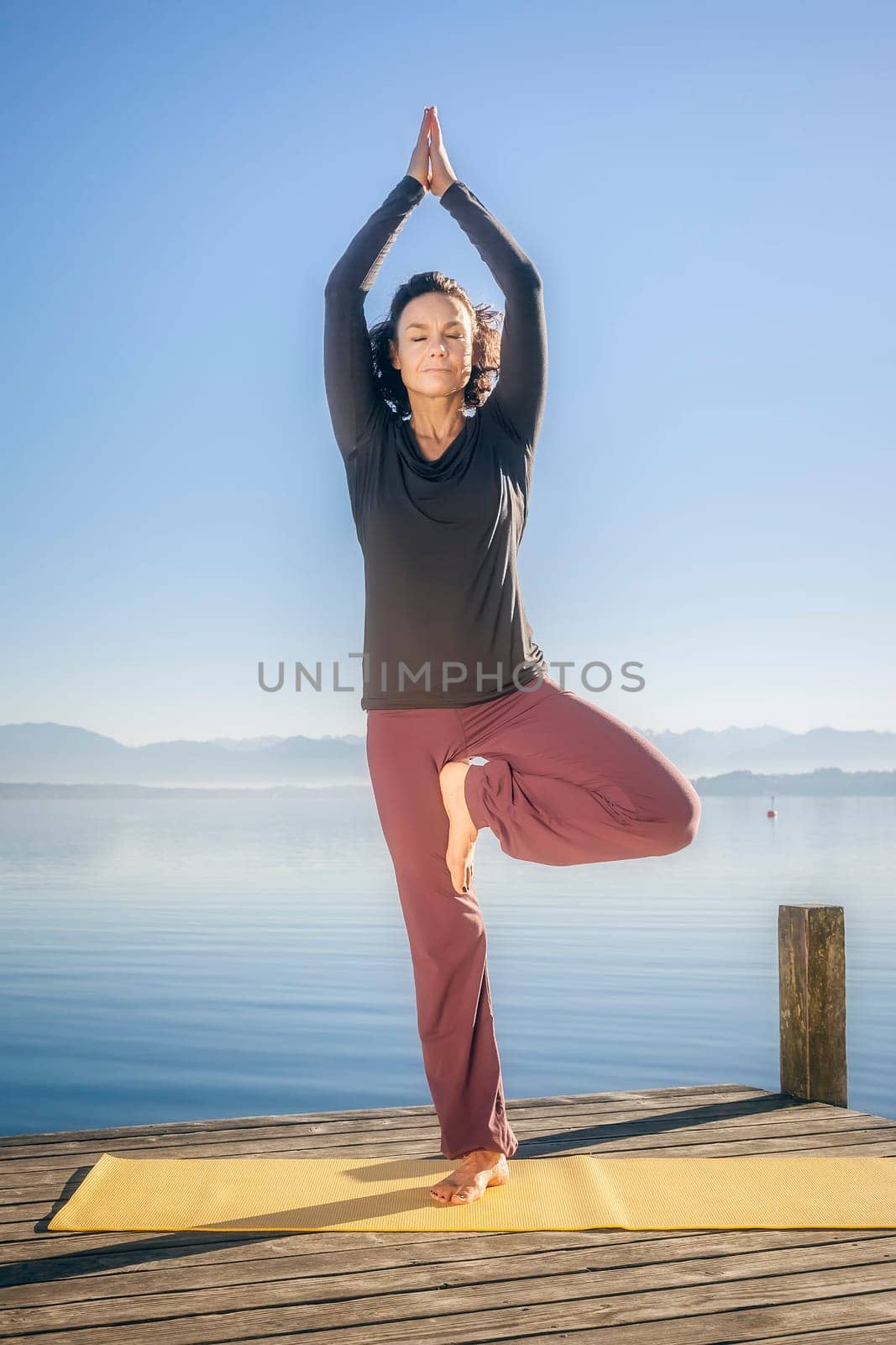 An image of a pretty woman doing yoga at the lake