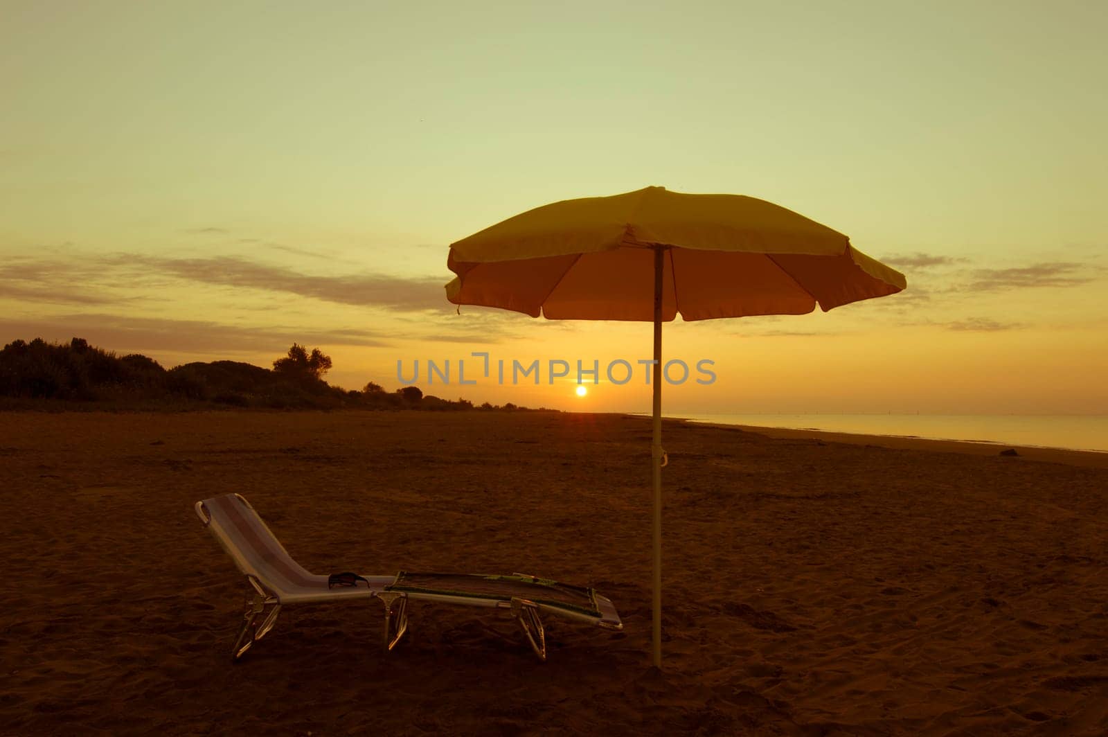 umbrella on the beach, with sun and sea on background