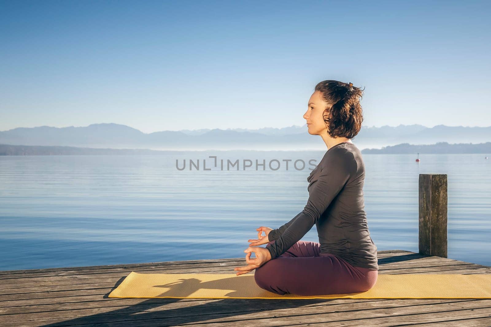 An image of a pretty woman doing yoga at the lake
