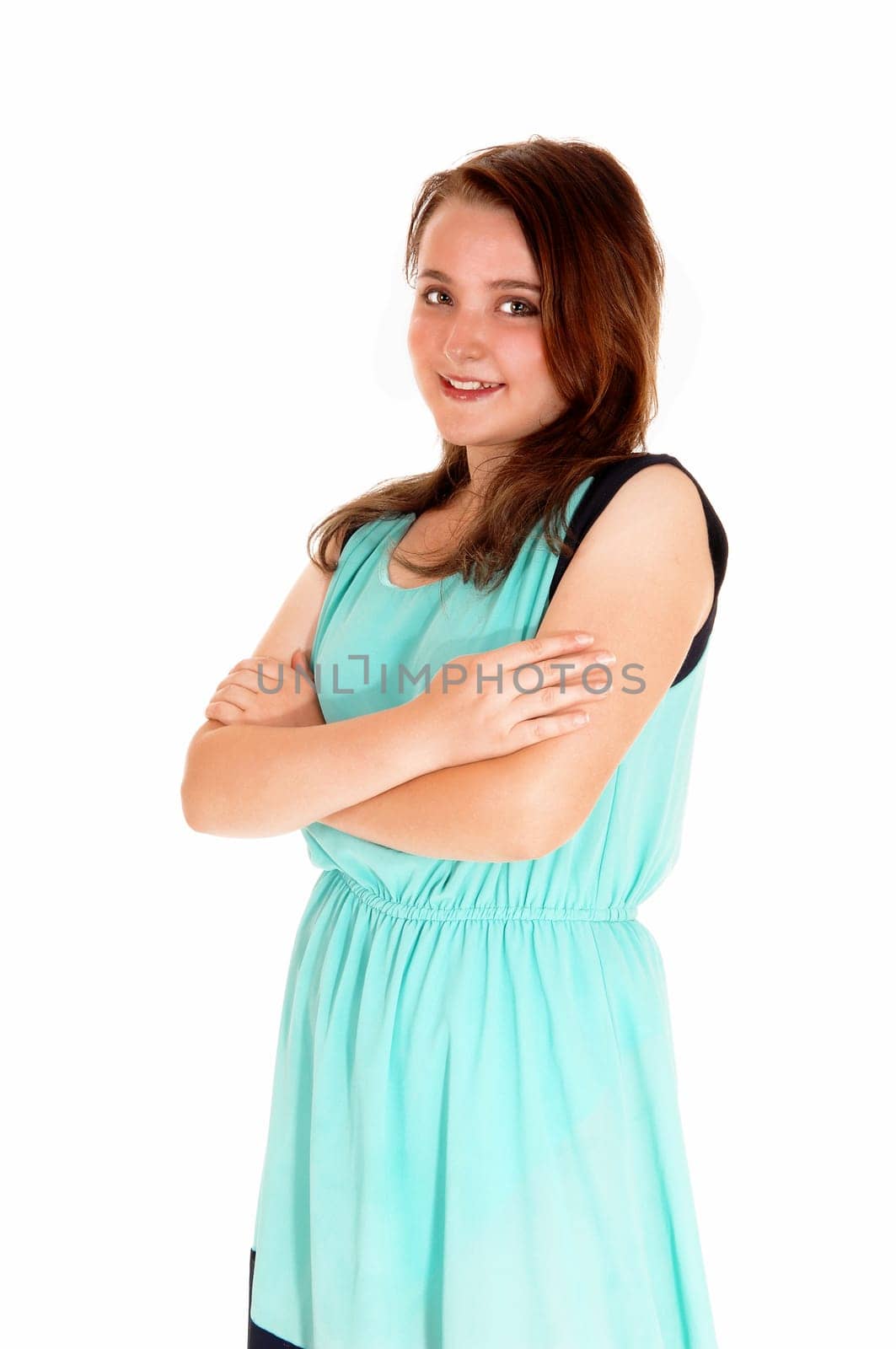 A portrait picture of a pretty teenage girl in a turquoise dress with her arms.crossed, isolated for white background..