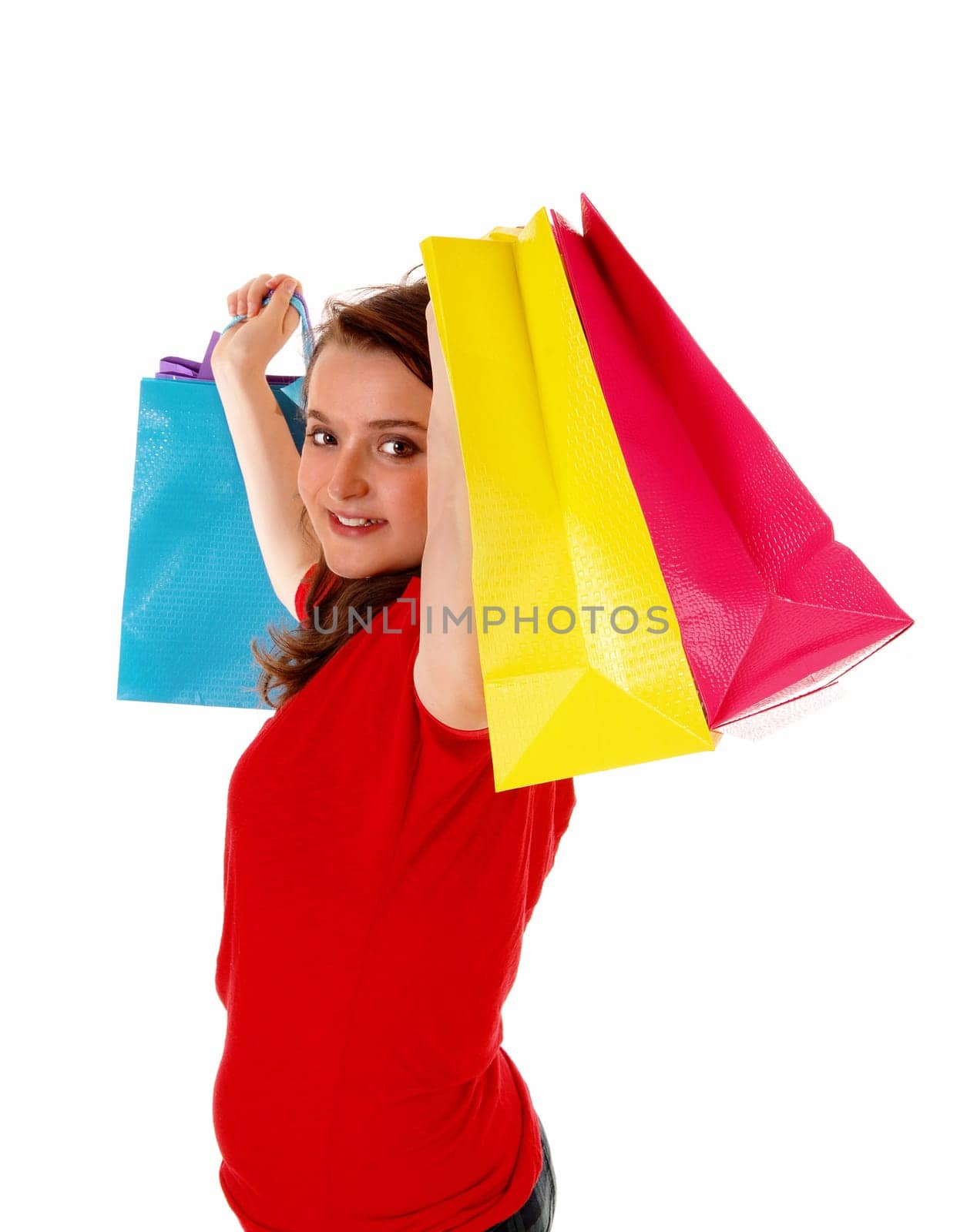A closeup picture of a beautiful teenager girl in a red sweater, lifting.up her colorful shopping bag's, isolated on white background..