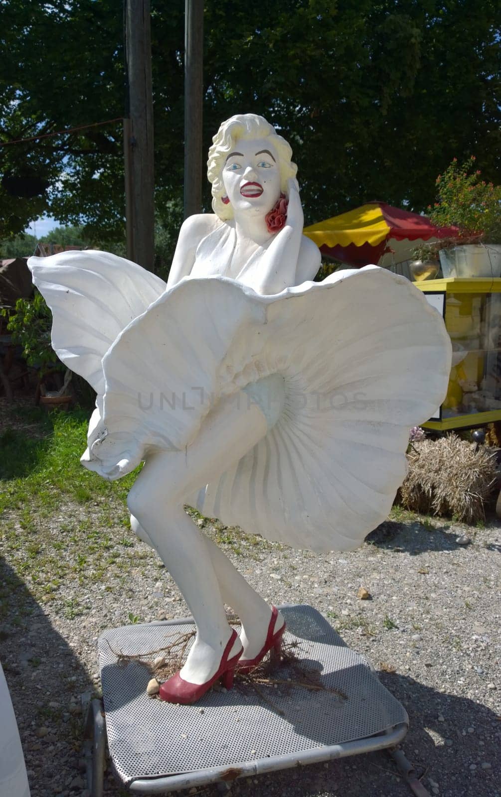 Hallbergmoos, Germany - Juli 17, 2014 .Statue of Marilyn Monroe in a well known cinematographic pose - the "Seven Year Itch"" subway grate moment -  in front of a second hand dealer shop"