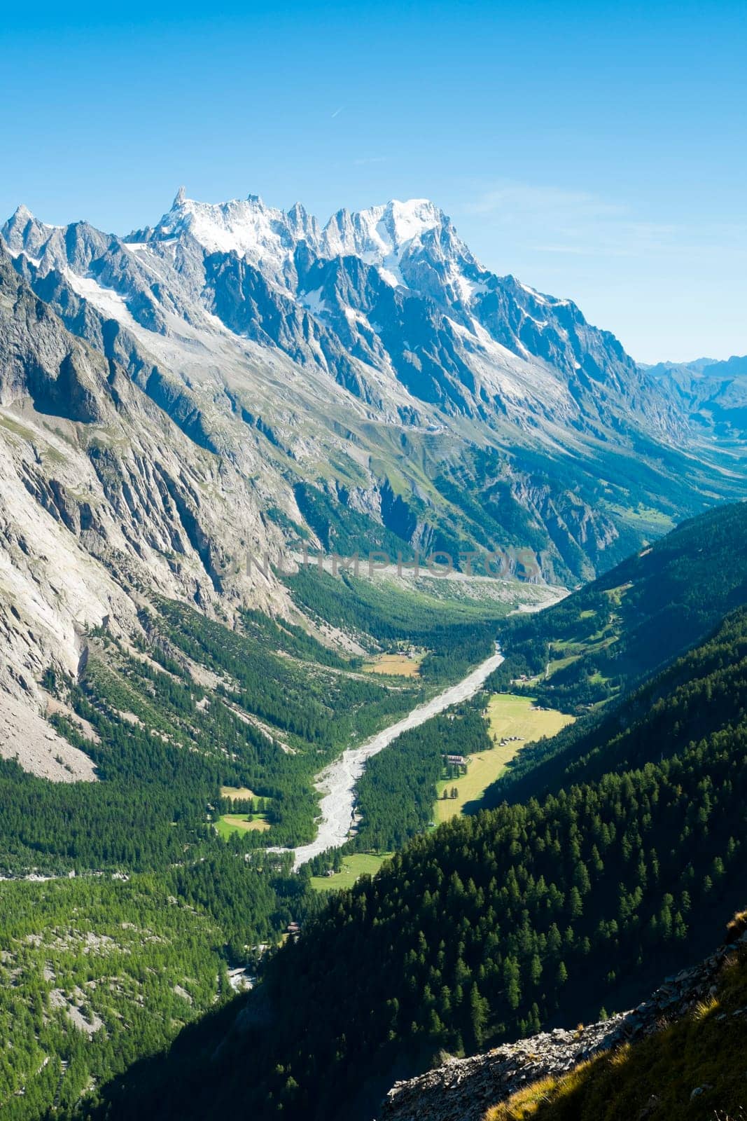 Val Veny valley in Val d'Aosta, in Italy, with Dora di Val Veny river and forests on hillsides.