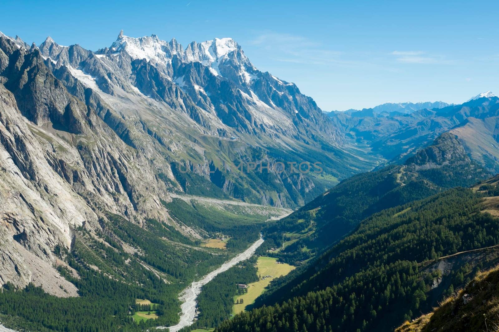 Val Veny valley in Val d'Aosta, in Italy, with Dora di Val Veny river and forests on hillsides.