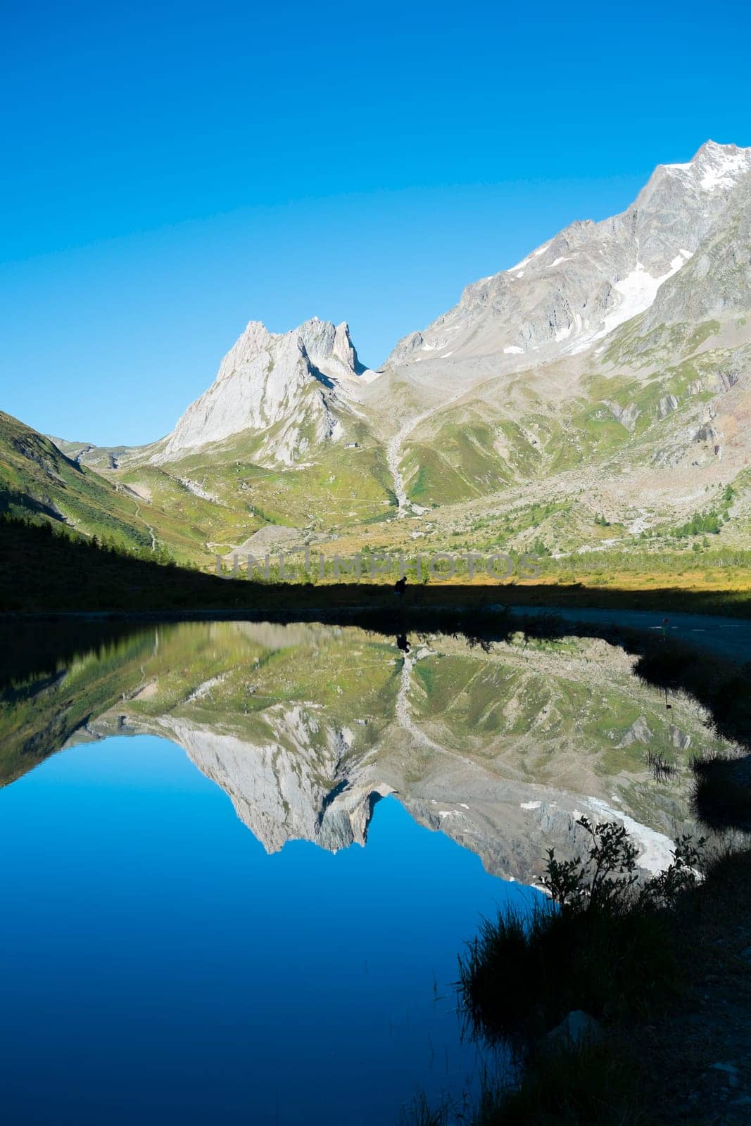 Limestone Pyramids reflected on Combal Lake waters in Val Veny, Italy