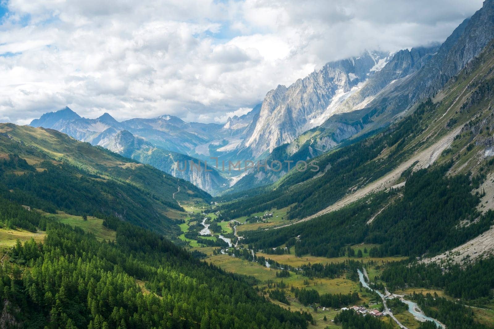 Early morning in Val Ferret valley in Italy, with overcast sky and rocky mountain range