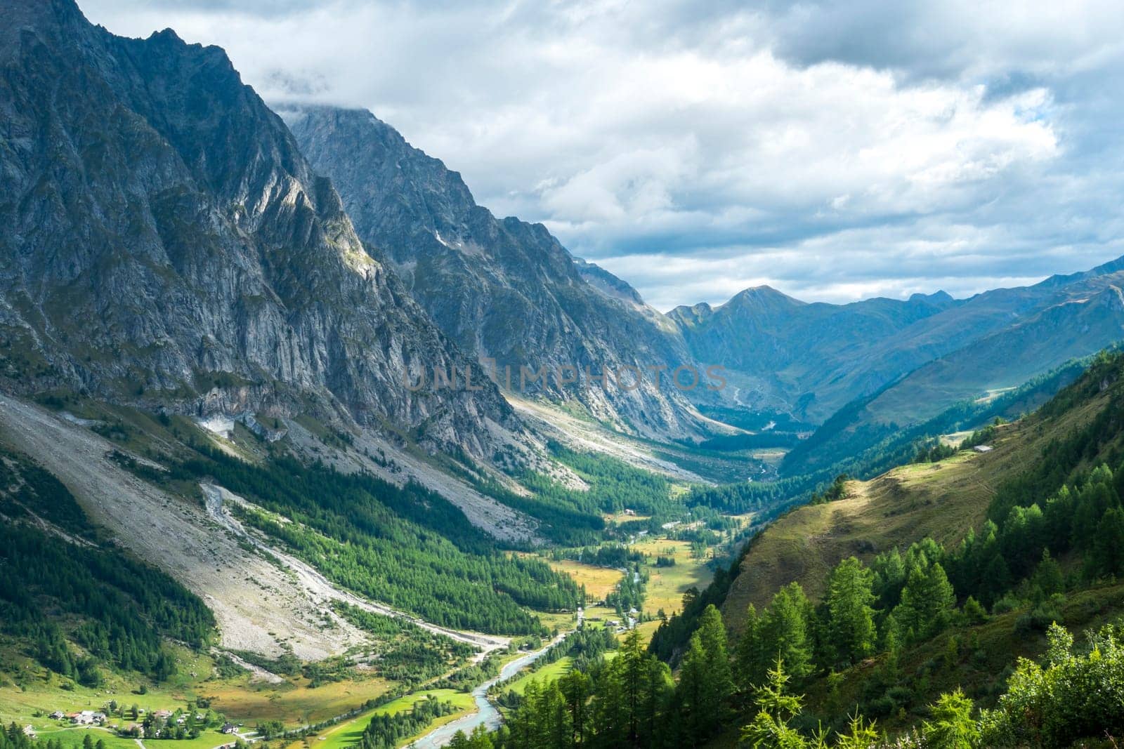 Early morning in Val Ferret valley in Italy, with overcast sky and rocky mountain range