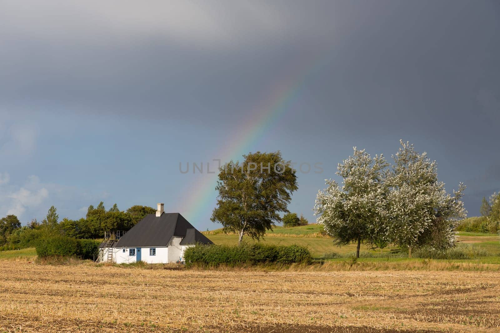 Small stone hut with a rainbow in the background