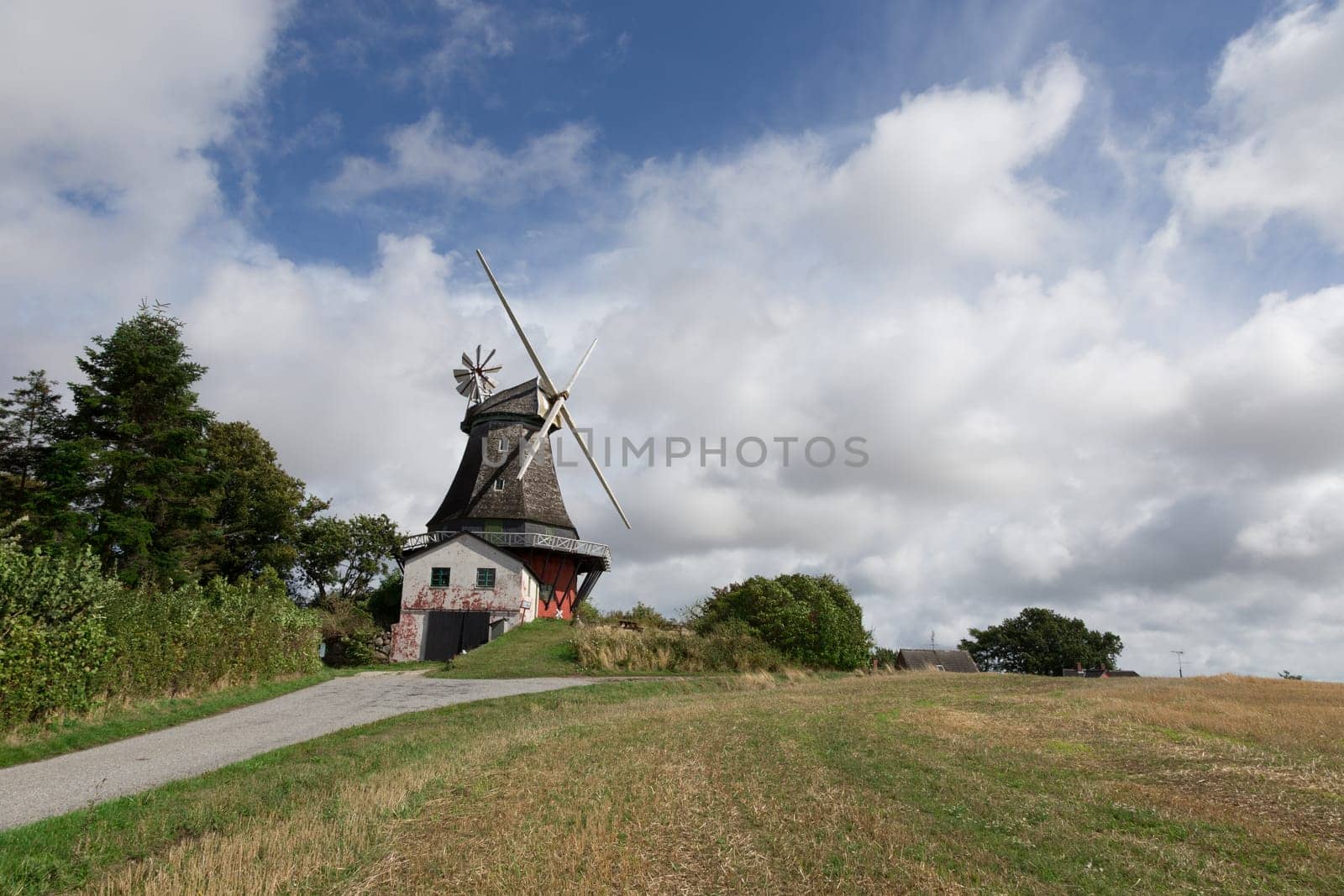 Windmill stands free on a hill in the middle of the field