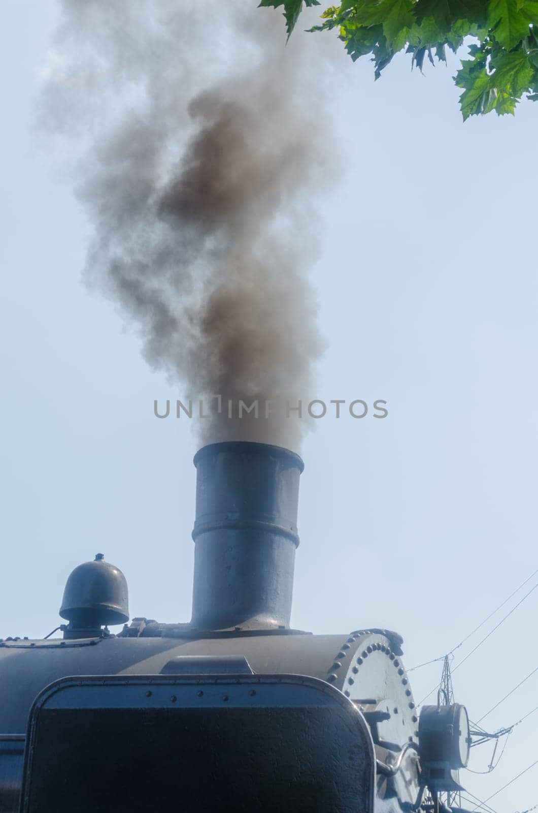 Steam locomotive under full steam at exit from a station.