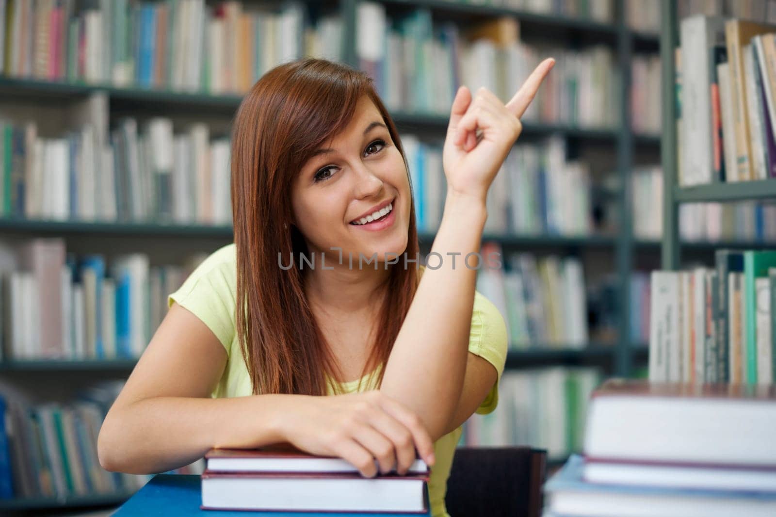 Beautiful student pointing at copyspace