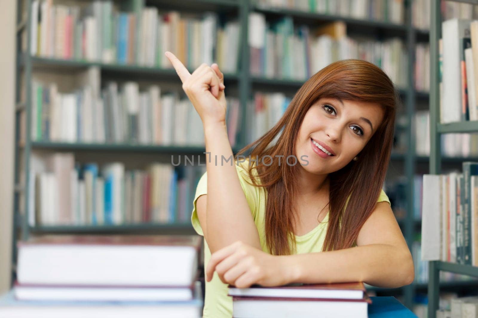 Beautiful student pointing at copyspace