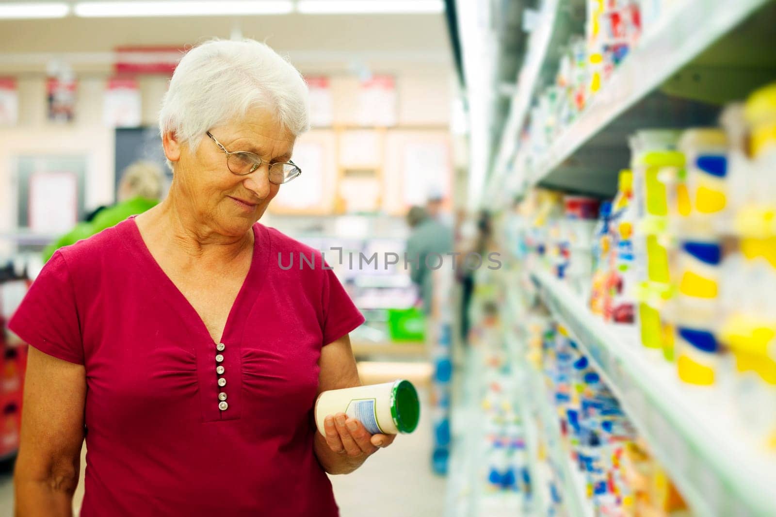 Senior woman checking label on jar