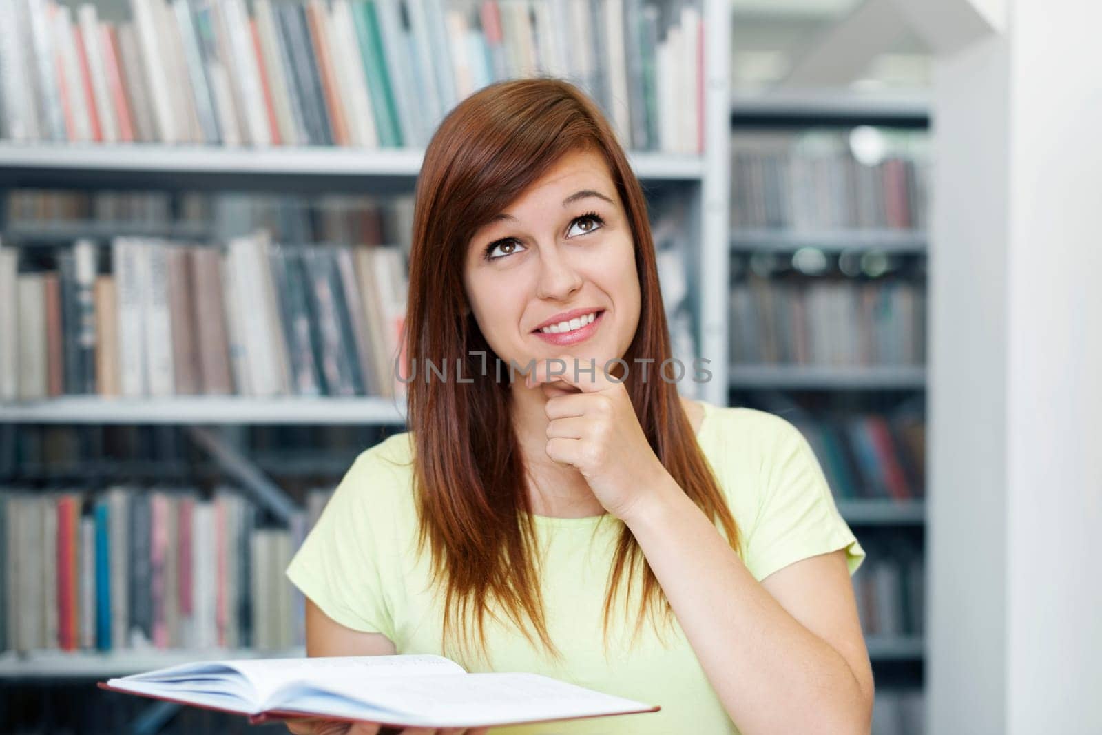 Young woman daydreaming in library