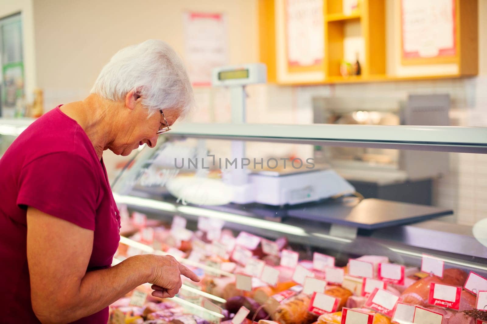 Senior woman in butchers shop