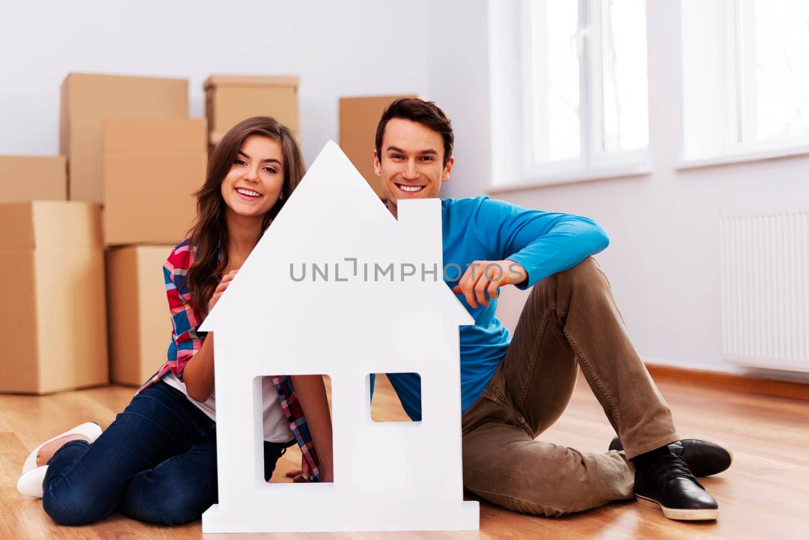 Young couple with house sign