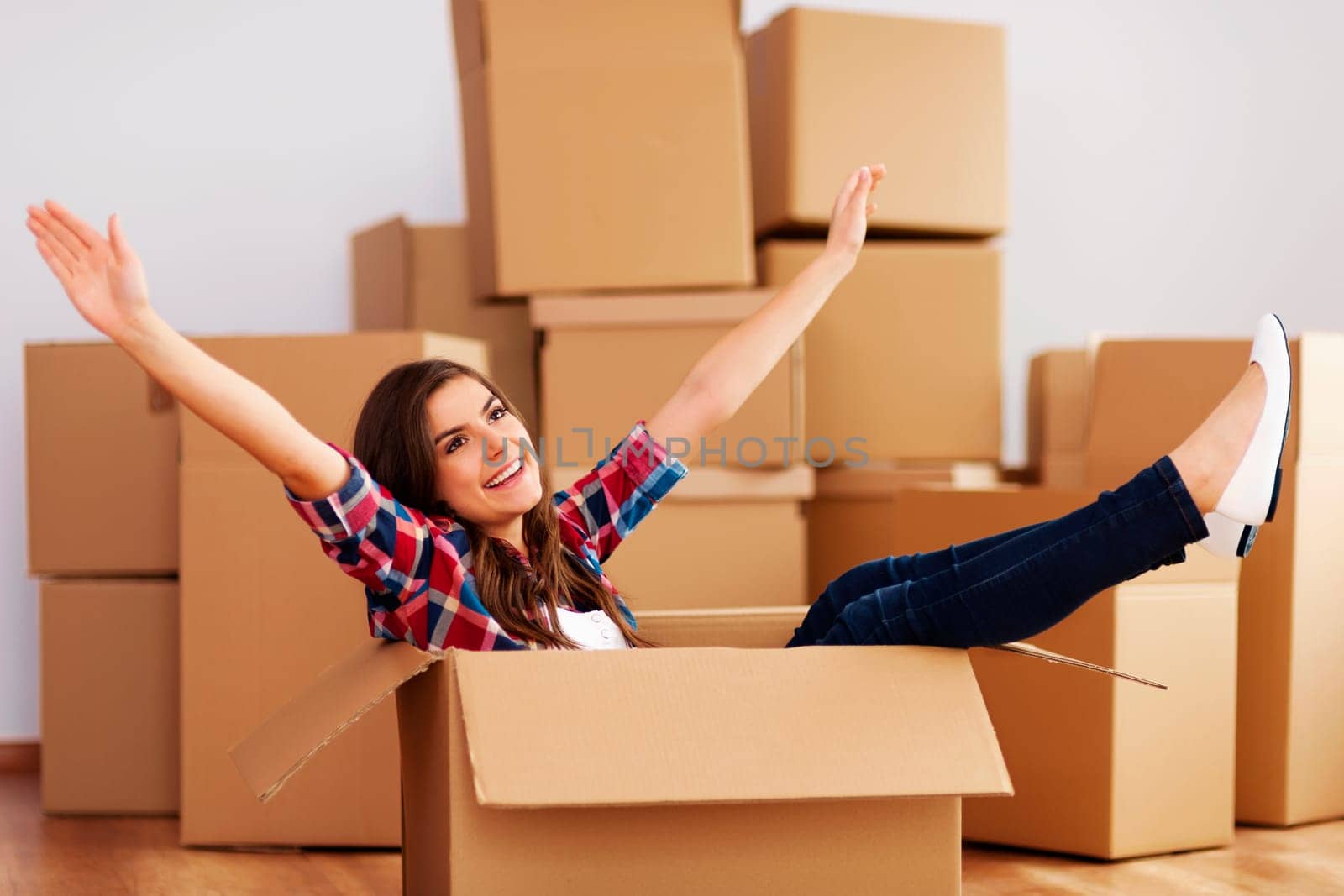 Cheerful woman sitting in a cardboard box