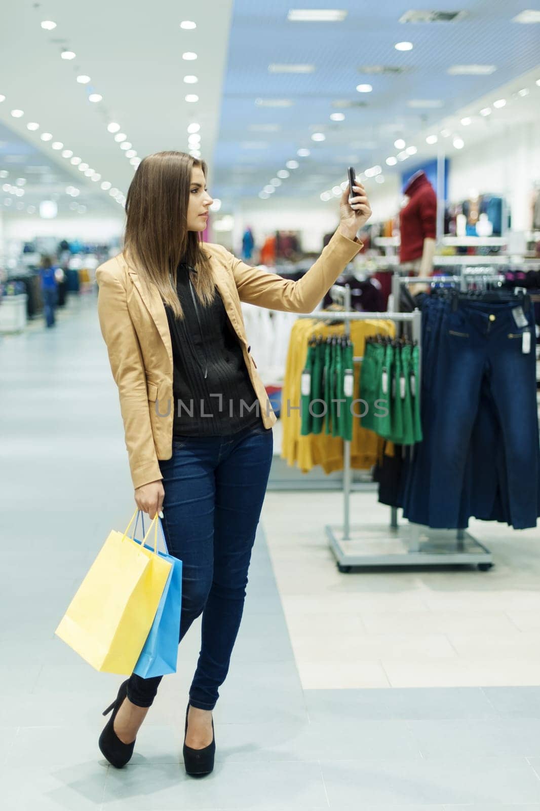 Young woman with shopping bags and mobile phone