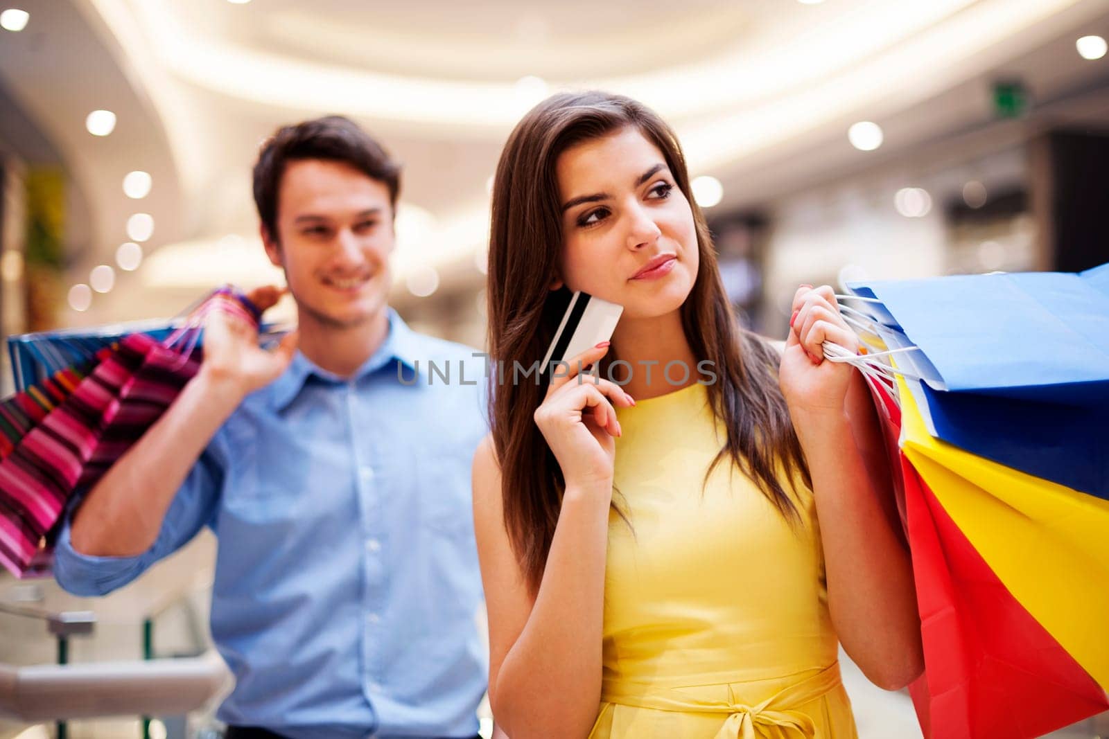 Focus young woman holding credit card and shopping bags