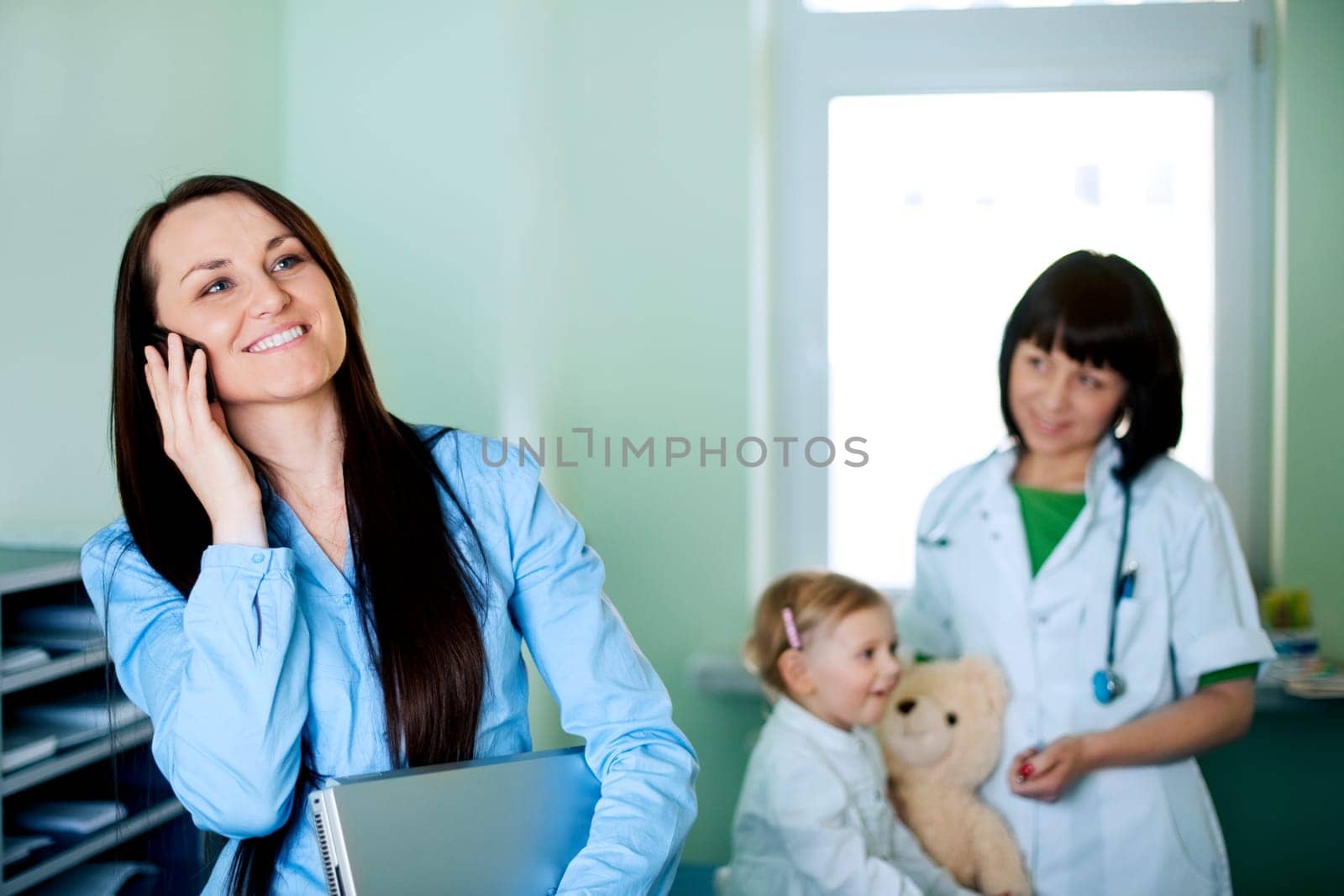 Busy businesswoman taking her daughter to the doctor