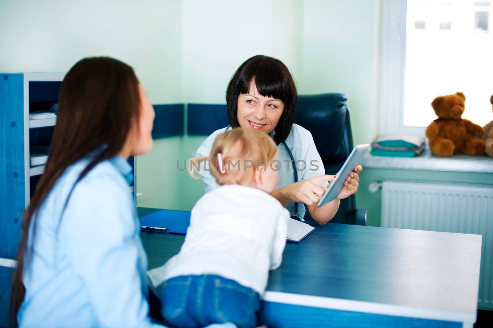 Doctor showing mother's medical results on the tablet