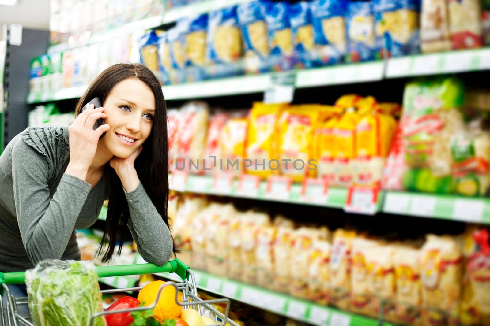 Beautiful woman on mobile phone at supermarket