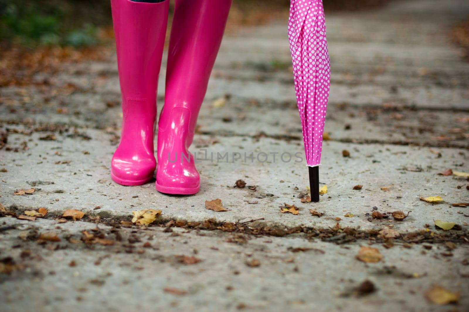 Woman with umbrella wearing rubber boots