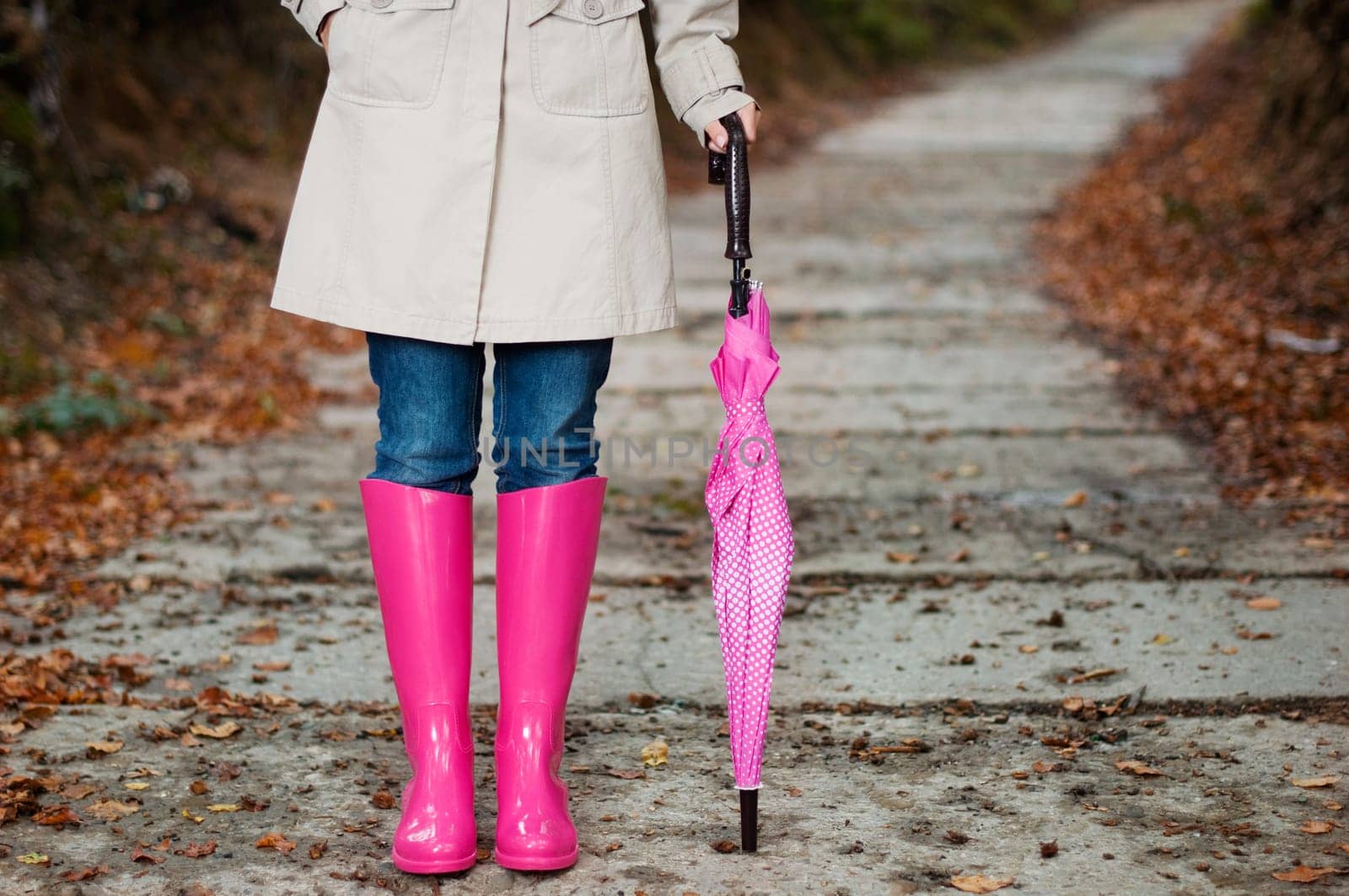 Woman with umbrella wearing rubber boots