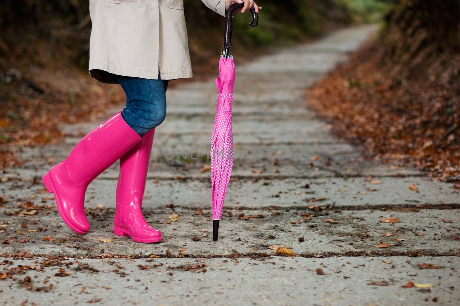 Woman with umbrella wearing rubber boots