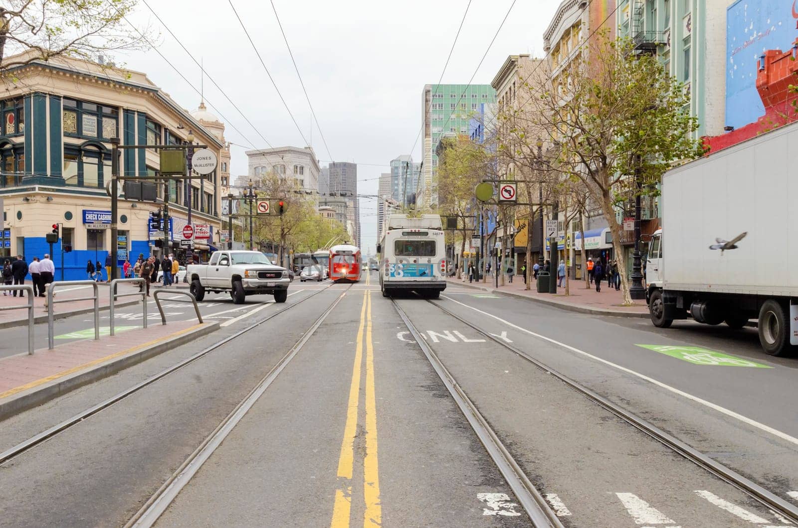 Market street in Downtown and South in San Francisco city, California, United States of America. A view of the road transport, shops, architecture, cable car lines and cityscape