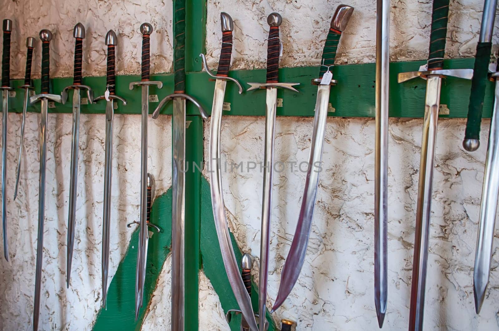 collection of ancient swords on a wall display