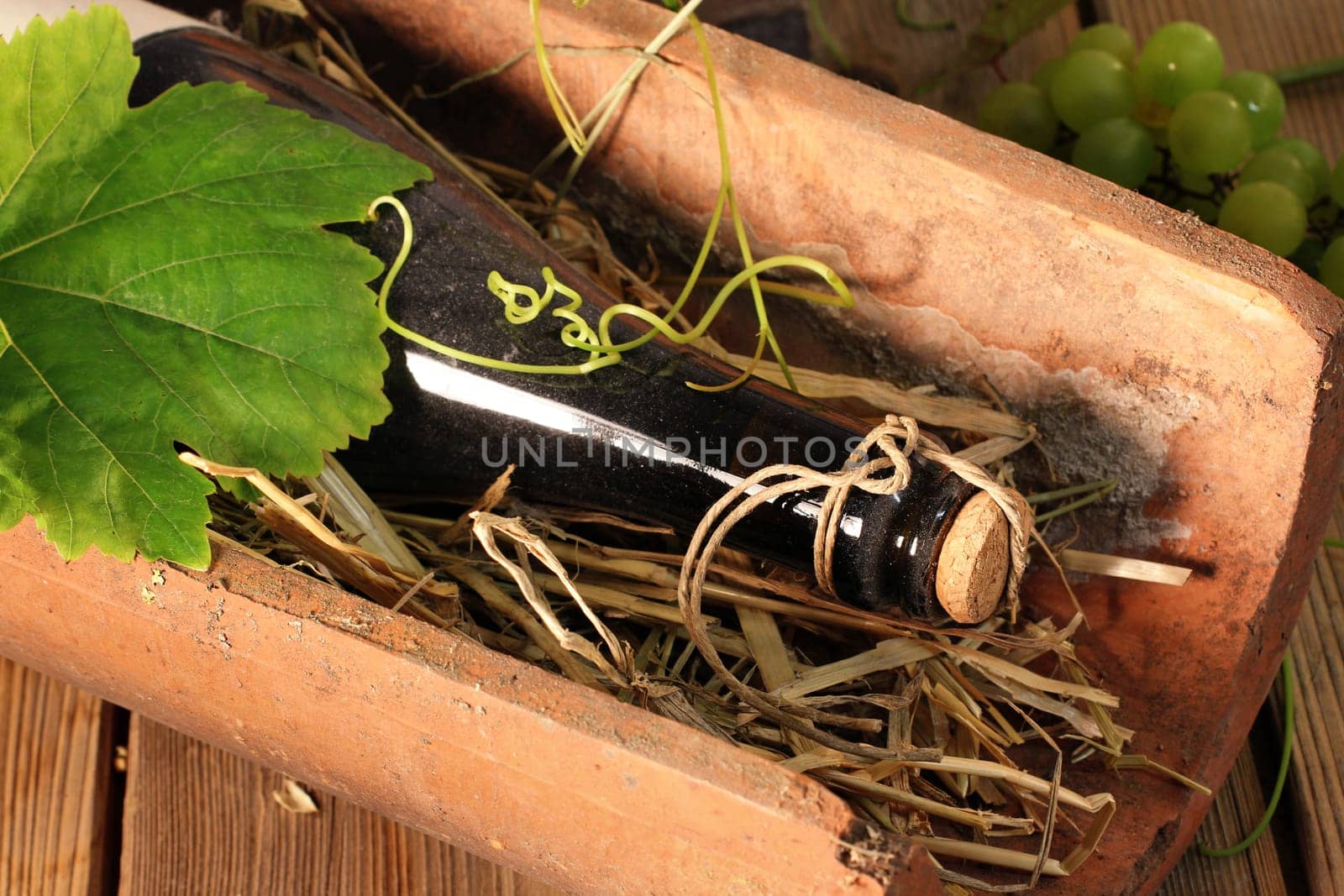 Wine bottle in clay brick on straw