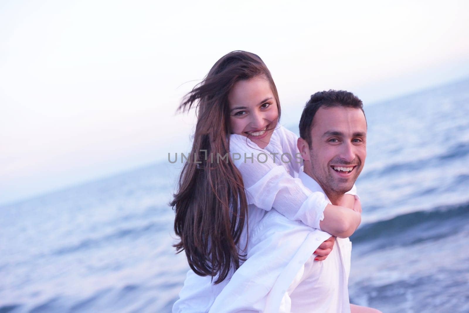 happy young romantic couple in love have fun on beautiful beach at beautiful summer day