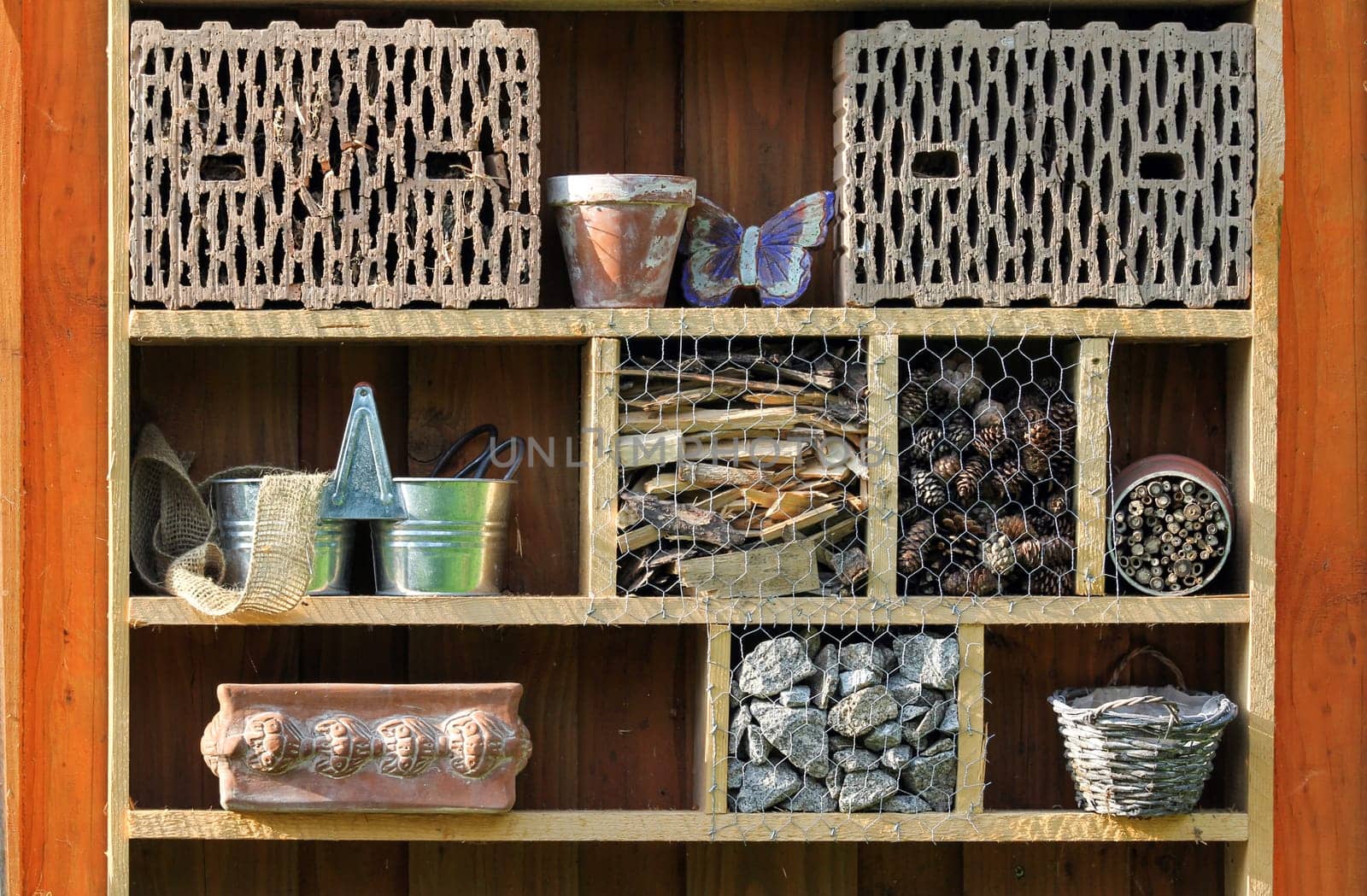 Shelf with insect hotel and garden utensils
