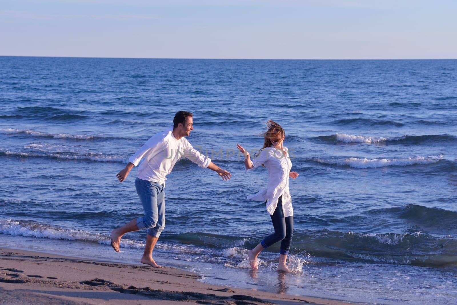 happy young romantic couple in love have fun on beautiful beach at beautiful summer day