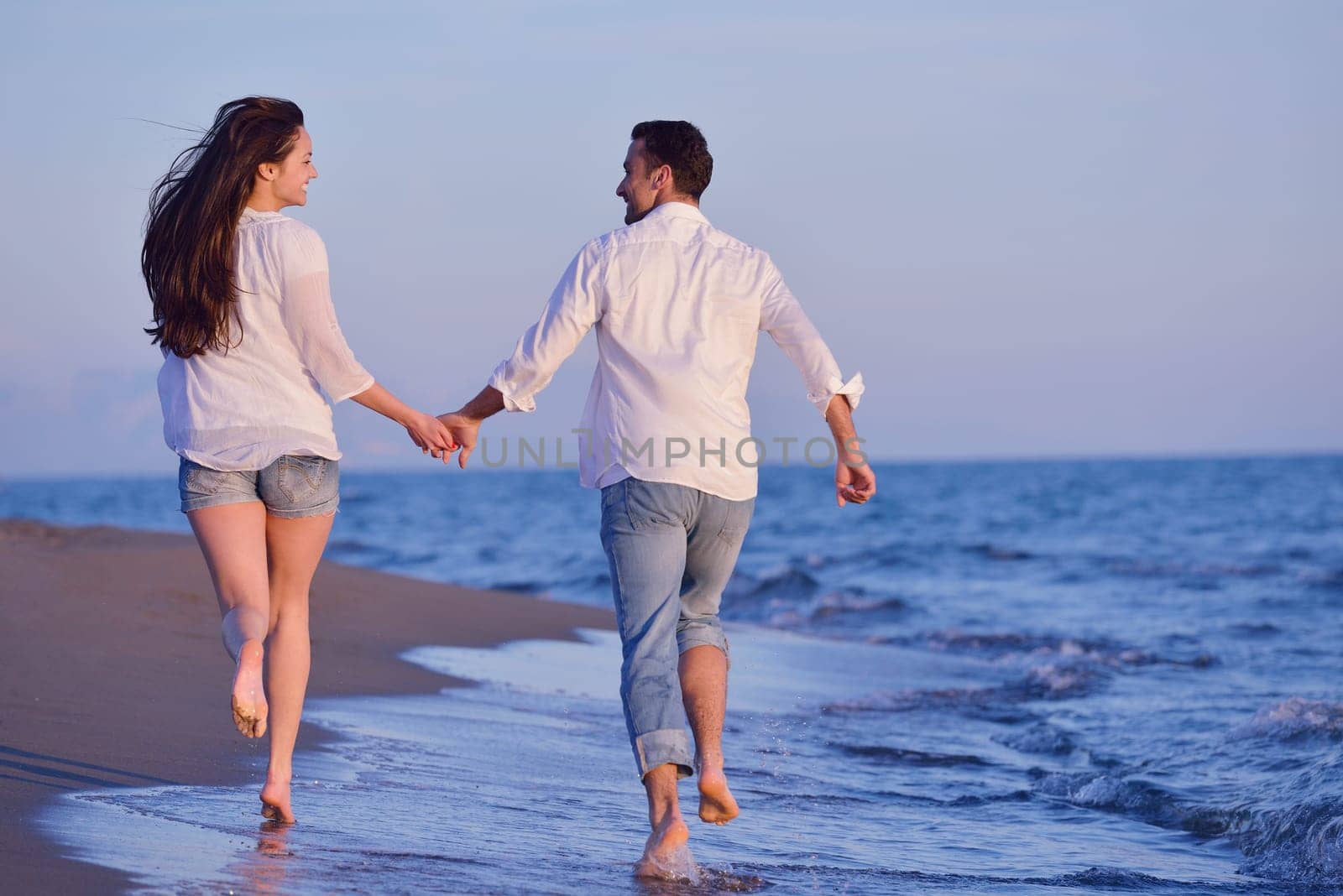 happy young romantic couple in love have fun on beautiful beach at beautiful summer day
