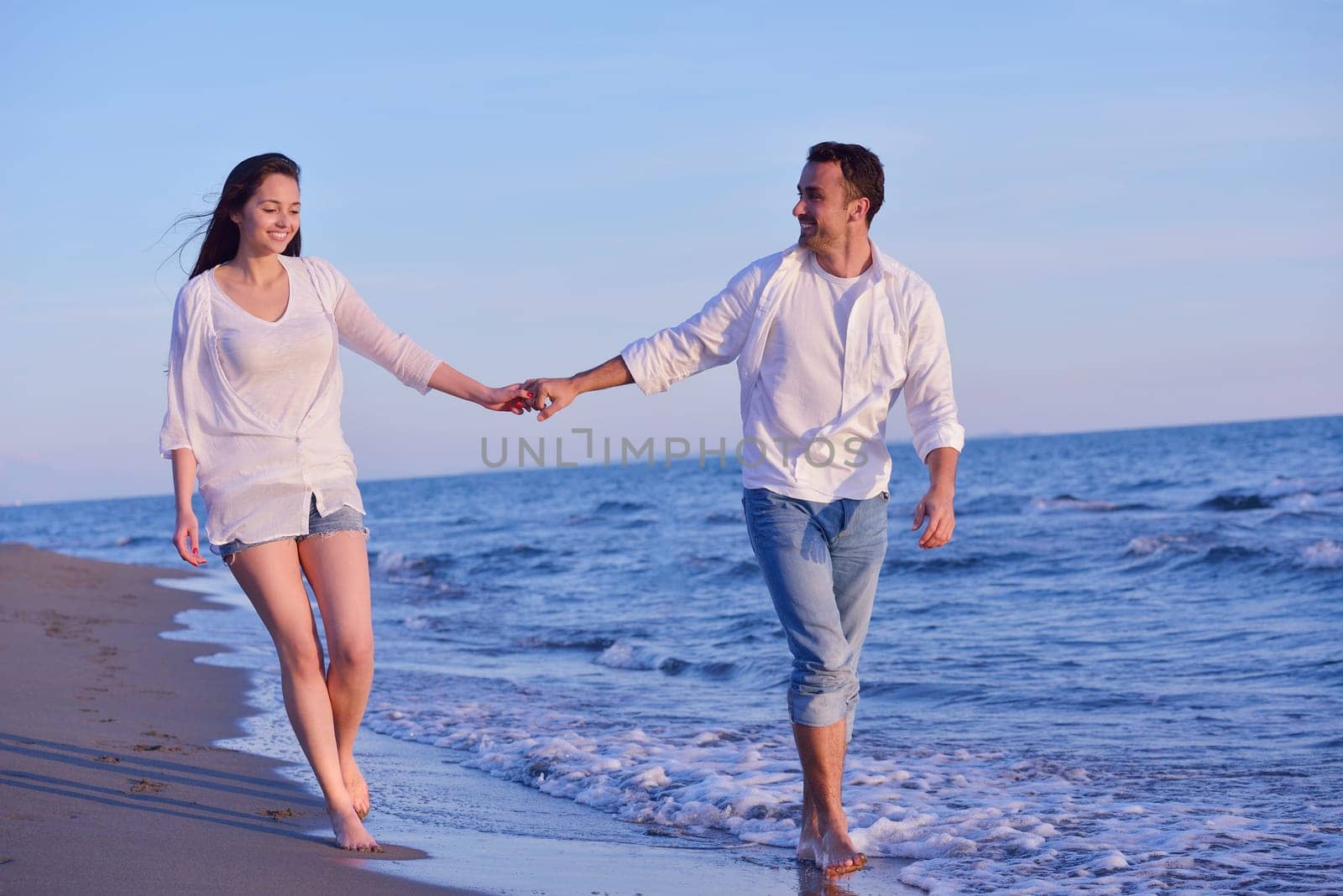 happy young romantic couple in love have fun on beautiful beach at beautiful summer day