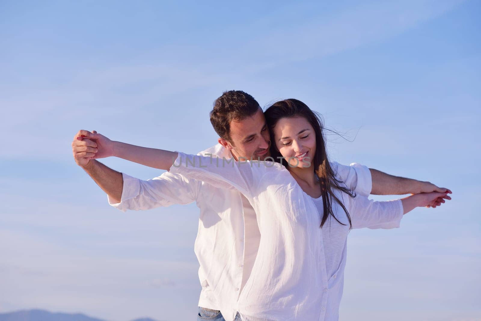 happy young romantic couple in love have fun on beautiful beach at beautiful summer day