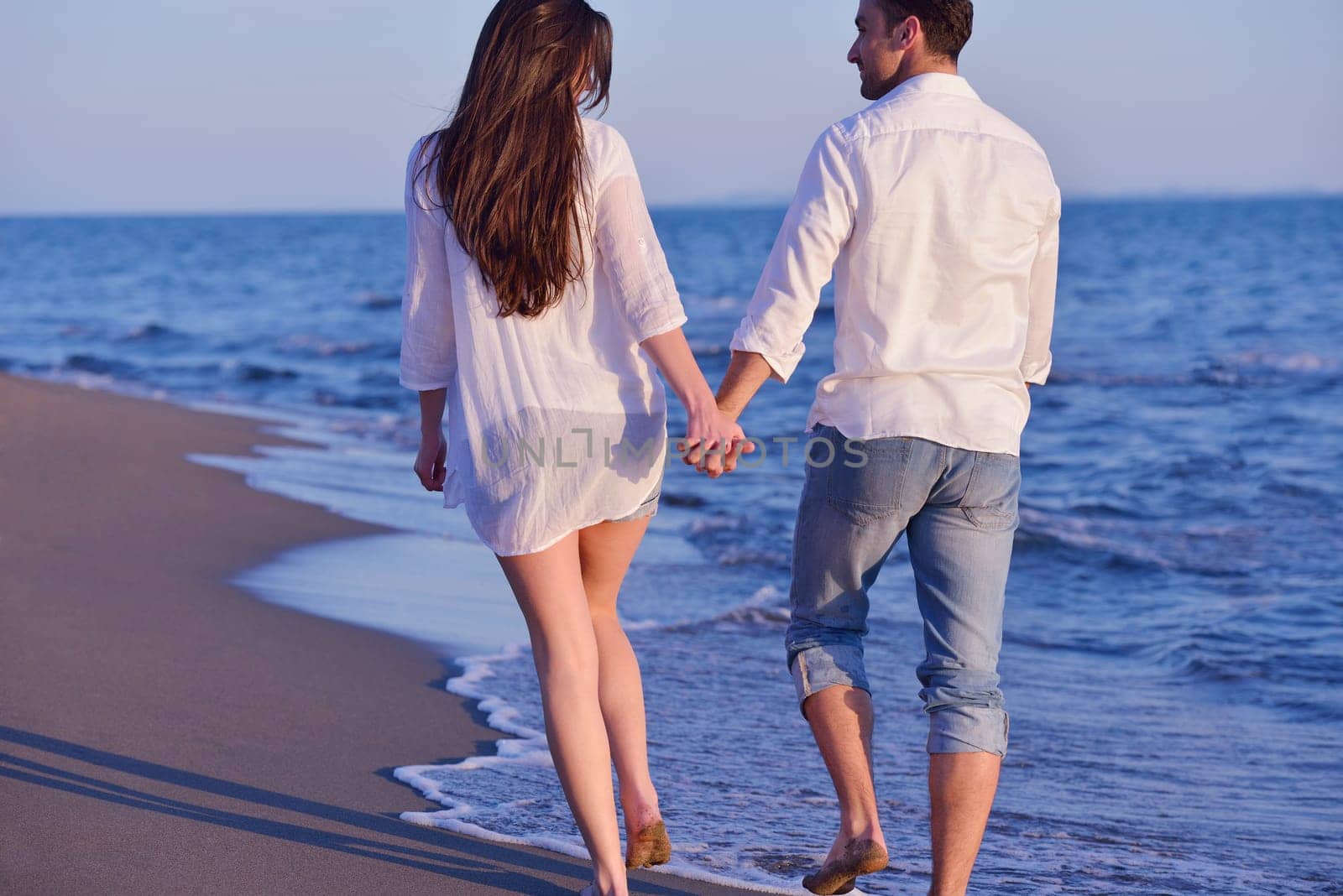 happy young romantic couple in love have fun on beautiful beach at beautiful summer day