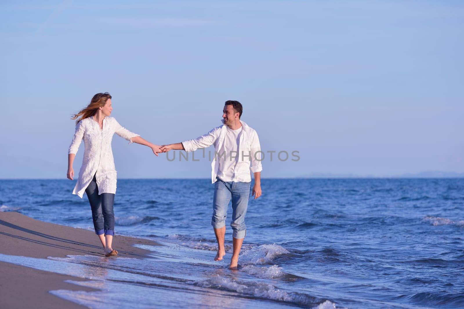 happy young romantic couple in love have fun on beautiful beach at beautiful summer day