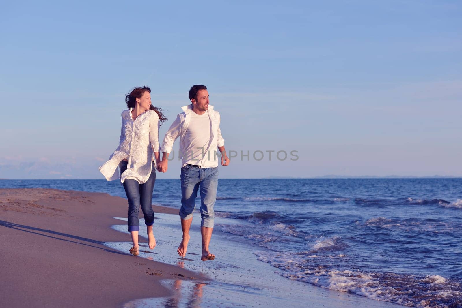 happy young romantic couple in love have fun on beautiful beach at beautiful summer day