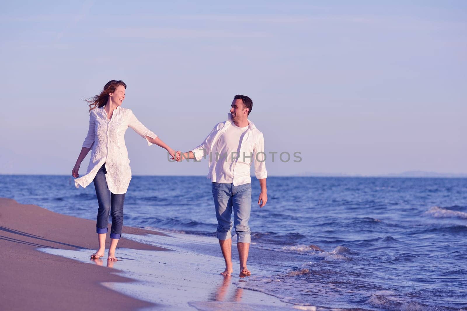 happy young romantic couple in love have fun on beautiful beach at beautiful summer day