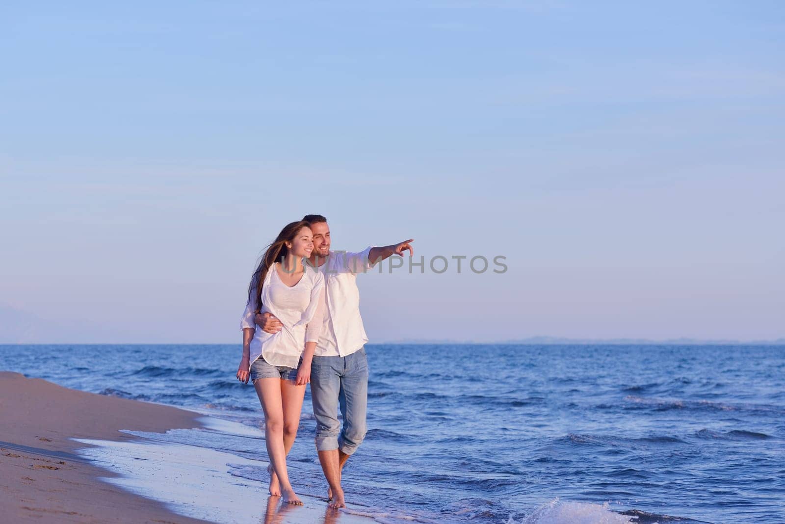 happy young romantic couple in love have fun on beautiful beach at beautiful summer day