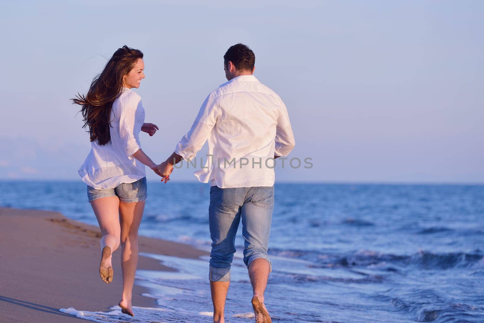 happy young romantic couple in love have fun on beautiful beach at beautiful summer day