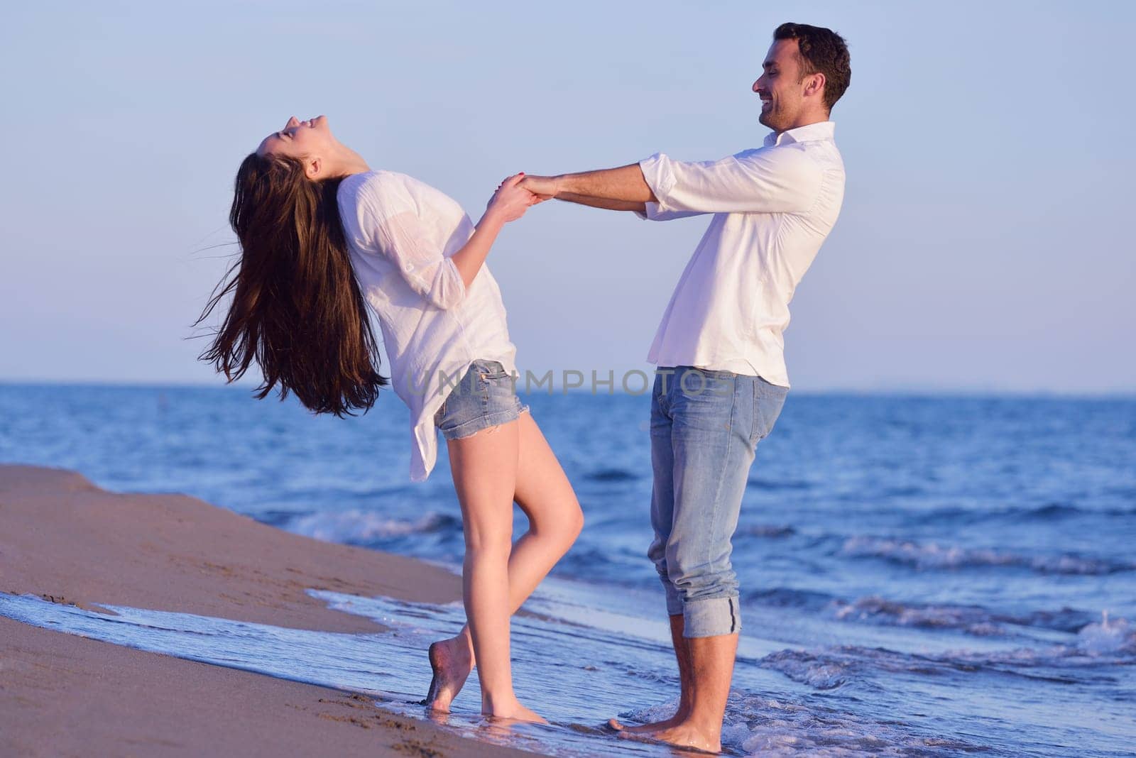 happy young romantic couple in love have fun on beautiful beach at beautiful summer day